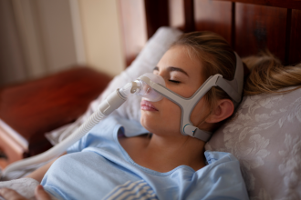 Woman sleeping with sleep apnea mask