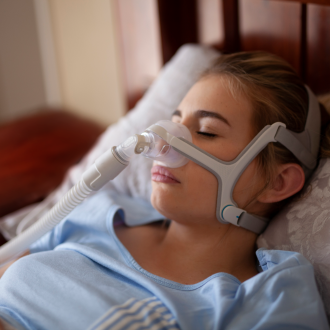 Woman sleeping with sleep apnea mask