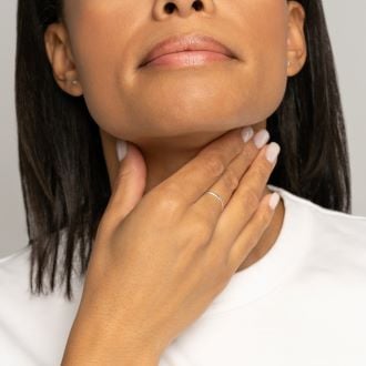 woman self palpation throat