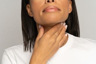 woman self palpation throat